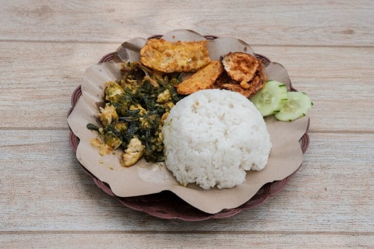Delicious dish of Nasi Ayam Geprek served with sambal and tempeh, showcasing Indonesian street food.